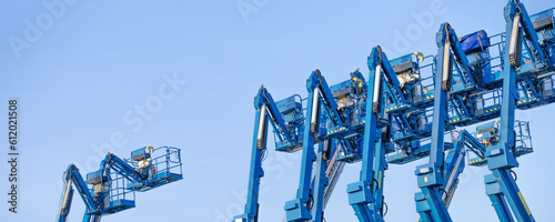 Articulated boom lift. Aerial platform lift. Telescopic boom lift against clear sky. Mobile construction crane for rent and sale. Maintenance and repair hydraulic boom lift service. Crane dealership. photo