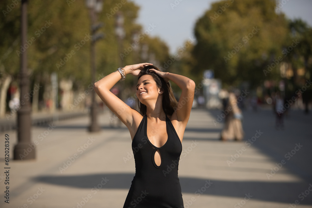 Beautiful young woman with straight brown hair, wearing an elegant black dress, touching her hair in sensual and seductive attitude. Concept fashion, beauty, sensuality, provocation, millennial. Beautiful young woman with straight brown hair, wearing an elegant black dress, touching her hair in sensual and seductive attitude. Concept fashion, beauty, sensuality, provocation, millennial.