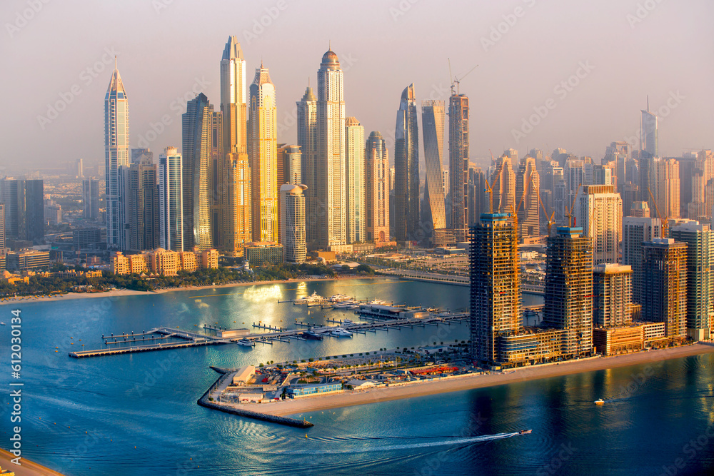 Obraz premium Dubai, UAE. Dubai Marina skyscrapers view at golden sunset with beautiful reflection in water.