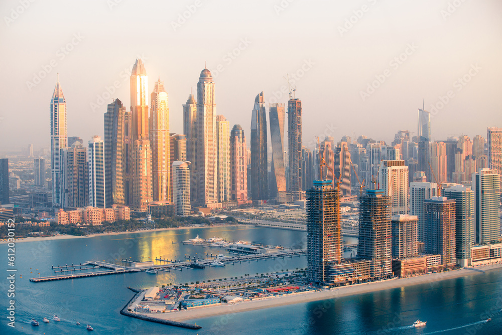 Fototapeta premium Dubai, UAE. Dubai Marina skyscrapers view at golden sunset with beautiful reflection in water.