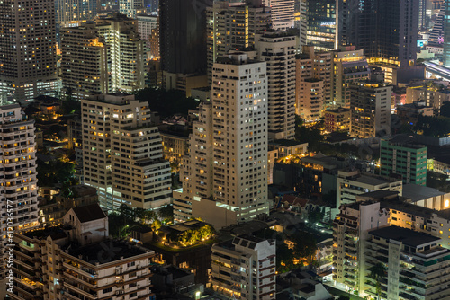 Night urban cityscape of asian illuminated Bangkok city with residential buildings in dusk. High-angle view on district lights in twilight