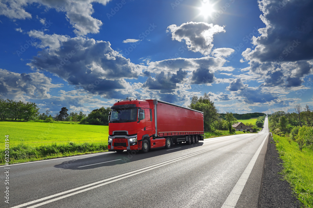 Cargo truck driving through landscape at sunset