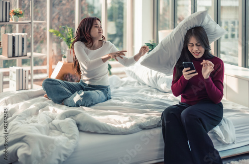 A Lesbian is annoyed, frustrated because her partner ignores and doesn't pay attention to her. Couples' conflicts make atmosphere tense and stressed. Misunderstanding can destroys relationships.