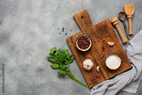 Culinary background. Wooden cutting boards, spices and parsley, gray grunge background. Top view, flat lay, copy space.