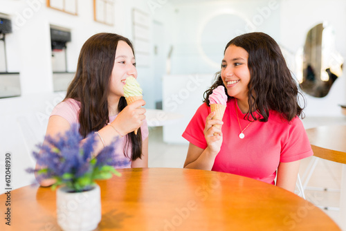Fun teen girls laughing hanging out at the ice cream shop