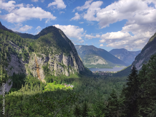 View on the valley, Hallstatt, Austria. Green summer mountains, blue sky, white clouds, fir trees, forest. Austrian Alps. Hiking place. Rocks, peaks.