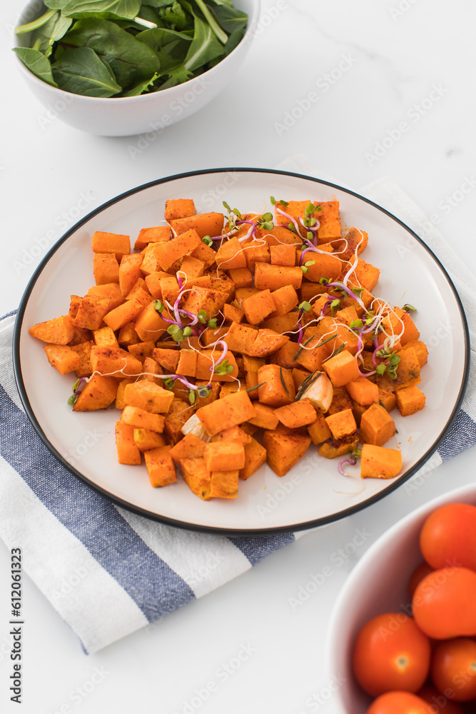 Baked sweet potato slices in a plate on the table. Healthy eating. Vegan dish. Baked sweet potato slices in a plate on the table. Healthy eating. Vegan dish.