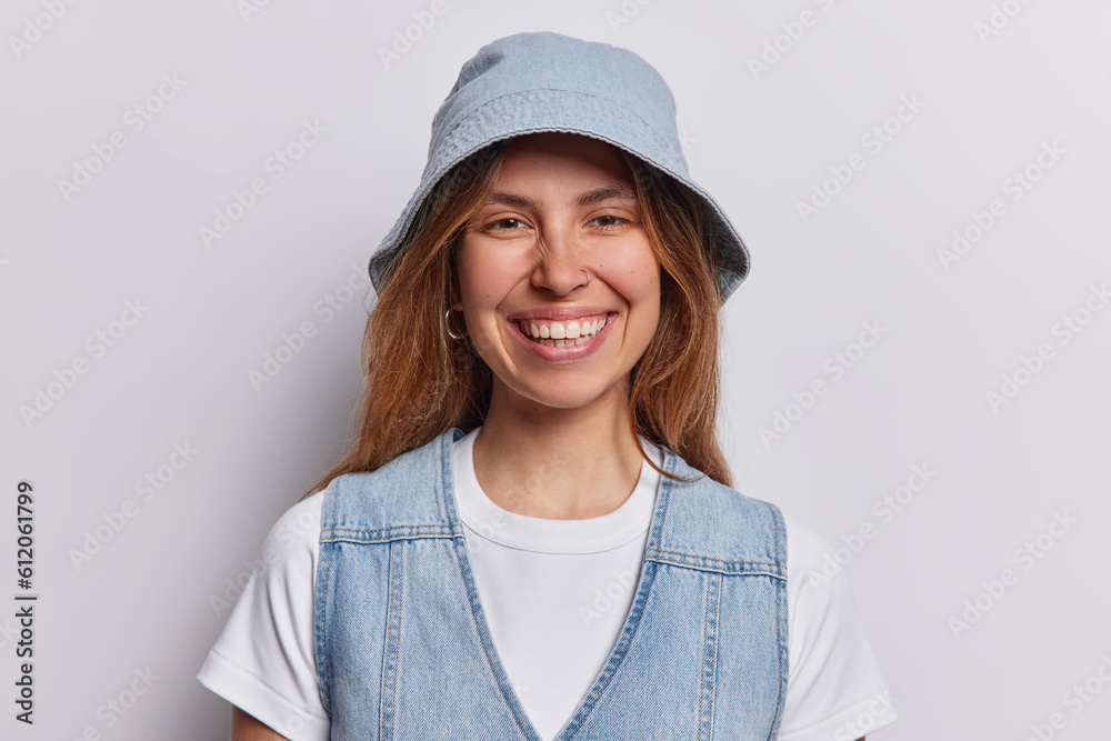 Radiant woman exudes joy as strikesdelightful pose in studio her infectious smile illuminatinge frame with pure happiness dressed in casual t shirt denim vest and panama isolated over white background Radiant woman exudes joy as strikesdelightful pose in studio her infectious smile illuminatinge frame with pure happiness dressed in casual t shirt denim vest and panama isolated over white background