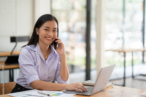 Asian businesswoman playing with mobile phone inside modern office
