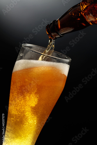 Pouring beer from a bottle into a glass.