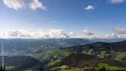 Timelapse video of the hills around Kastelruth (Castelrotto). Clouds pass over the distant snow-capped alps. Seiser Alm (Alpe di Siusi) in the Dolomites, South Tyrol, Italy.  photo