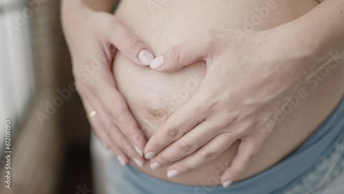 Wallpaper Mural Young pregnant woman doing heart gesture with hands on belly at bedroom Torontodigital.ca