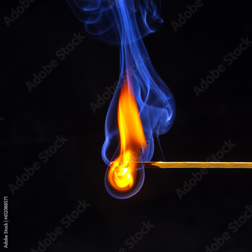 Flashed and burning wooden match on a dark background close-up. Bright fire and smoke from a burning tree.