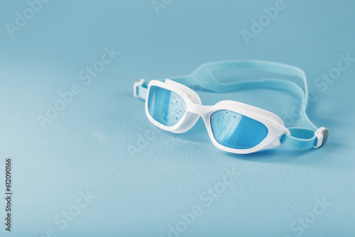 Swimming goggles in a white frame with on a blue background