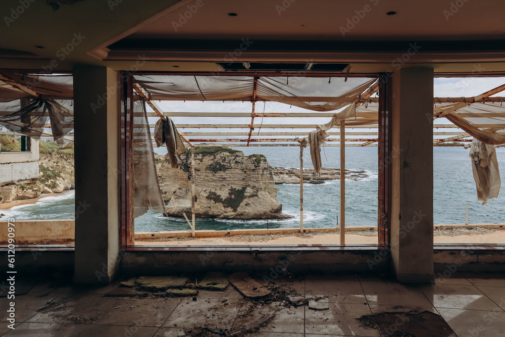 Obraz premium Beirut, Lebanon — 24.04.2023: Abandoned restaurant on the waterfront of Beirut overlooking the famous Pigeon Rocks