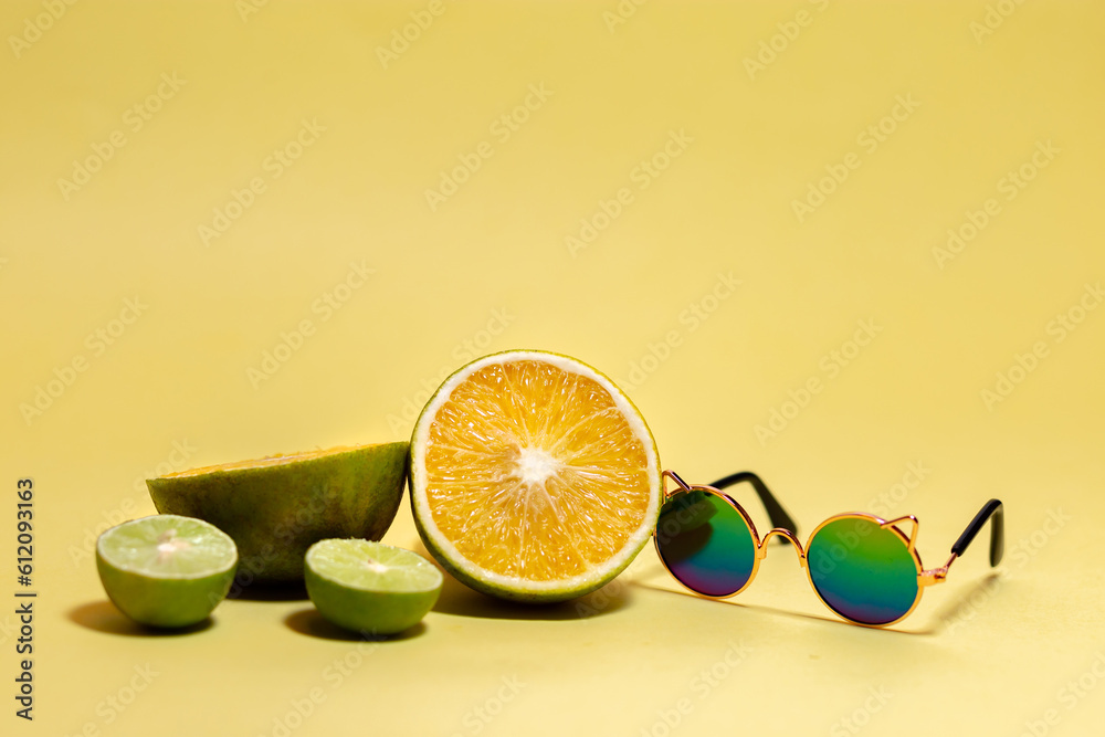 Banner con espacio para texto, frutas frescas y naturales naranjas y limones en rodajas, gafas de sol y sonrisas en fondo amarillo, concepto de dia mas feliz del año, happy yellow day, verano. - obrazy, fototapety, plakaty 
