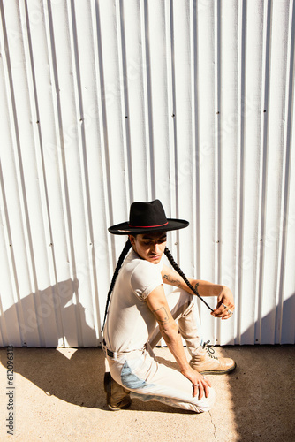 DIANA DAWN + QUEEN OF THE RODEOFashionable queer Mexican native person in hat and jewelry outdoors in the desert photo