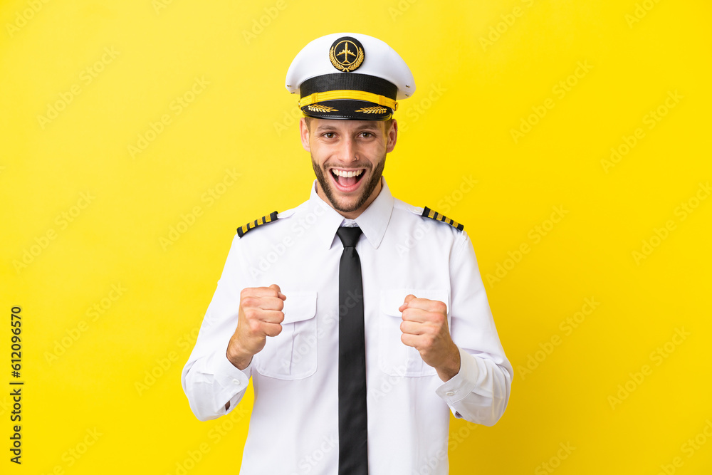 Airplane caucasian pilot isolated on yellow background celebrating a victory in winner position Airplane caucasian pilot isolated on yellow background celebrating a victory in winner position