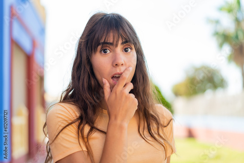 Young woman at outdoors surprised and shocked while looking right