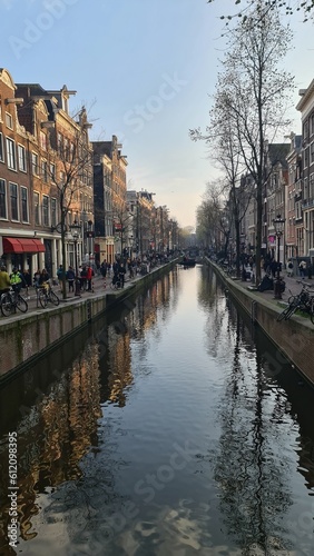 Amsterdam, Netherlands - April 22, 2023: Discovering the city of Amsterdam in spring days. Biking around Amstel river, old houses and nice view to the old part of the city.