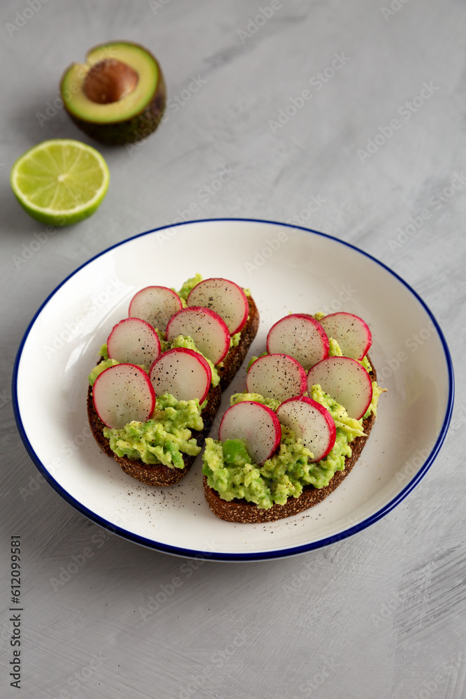 Homemade Radish Avocado Toast with Salt and Pepper on a Plate, side view. Homemade Radish Avocado Toast with Salt and Pepper on a Plate, side view.