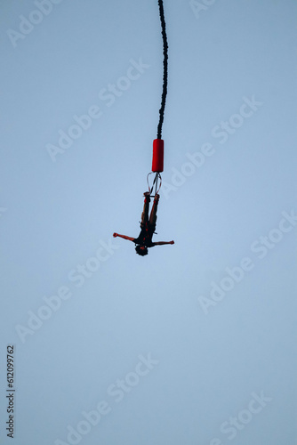 Bungee jumping from a great height while connected to a large elastic cord