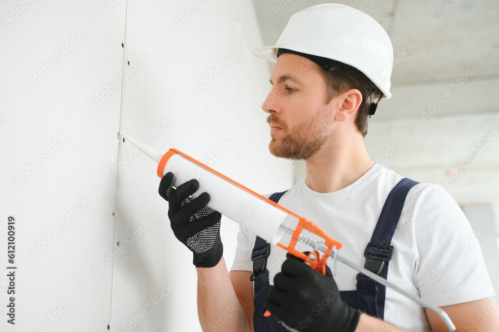 Professional Workman Applying Silicone Sealant With Caulking Gun on the Wall Professional Workman Applying Silicone Sealant With Caulking Gun on the Wall