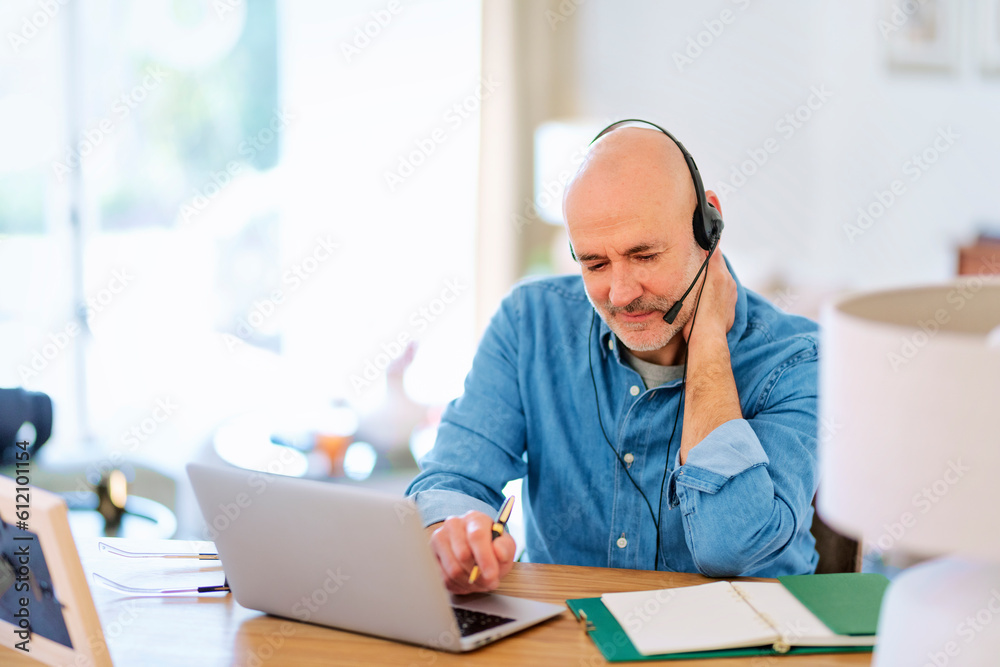 Fototapeta premium Call center assistant businessman using laptop and headset and working from home