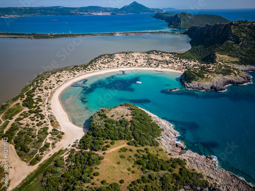 Aerial view of Voidokilia beach on Peloponnese in Messinia / Greece with clear blue water and catamaran sailing boat in the bay
