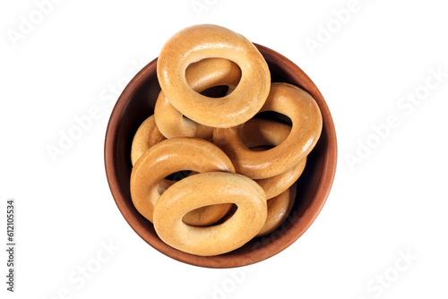 Dry bagels in a bowl isolated on white, top view