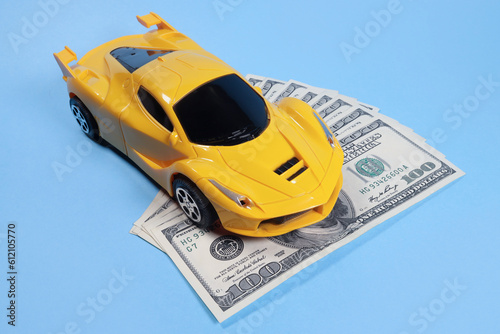 Toy car on dollars, cost concept, auto insurance