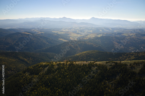 Aerial landscape view of high peaks with dark pine forest trees in wild mountains
