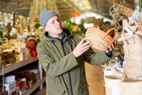 Portrait of man searching wicker basket for storage at store