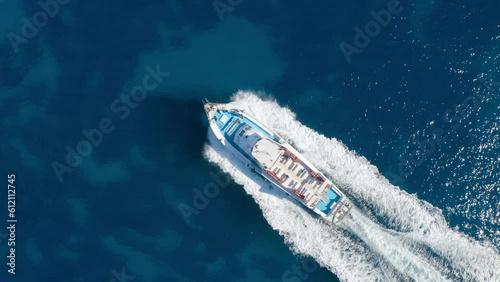 Aerial view of beautiful floating yacht in blue sea at sunny day in summer. Sardinia island, Italy. Top drone view of speed boat, sea coast, transparent water. Travel. Tropical landscape. Yachting