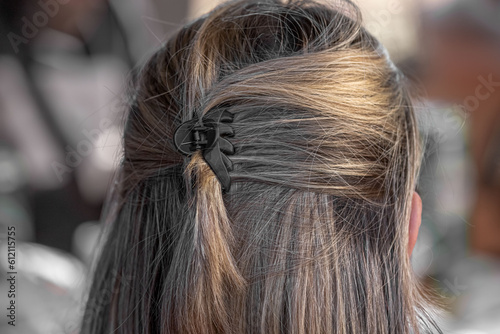 Back view of a simple female hairstyle. Hair dye. Simple female hairstyle. Collected hair. Hair clip. A quick way to collect hair. Light strands.