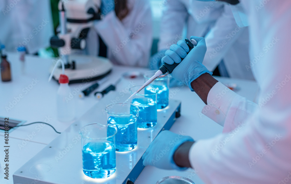 Close up of Scientists in Chemical Lab working with microscope, test tubes, and pipette. Close up of Scientists in Chemical Lab working with microscope, test tubes, and pipette.
