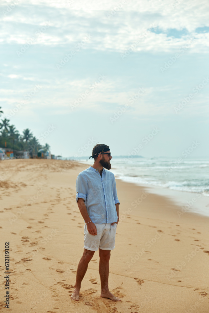 Portrait of handsome bearded man in shirt on the beach