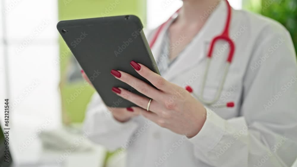 Young blonde woman doctor using touchpad at clinic Young blonde woman doctor using touchpad at clinic