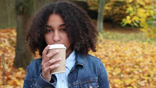 Wallpaper Mural Beautiful mixed race African American girl teenager young woman wearing a blue denim jacket outside sad or depressed drinking coffee or tea Torontodigital.ca