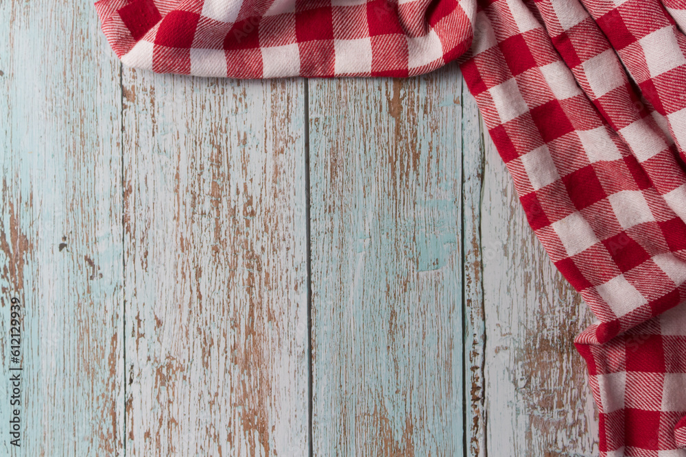 Obraz premium Red and white checkered tablecloth on a vintage wooden table