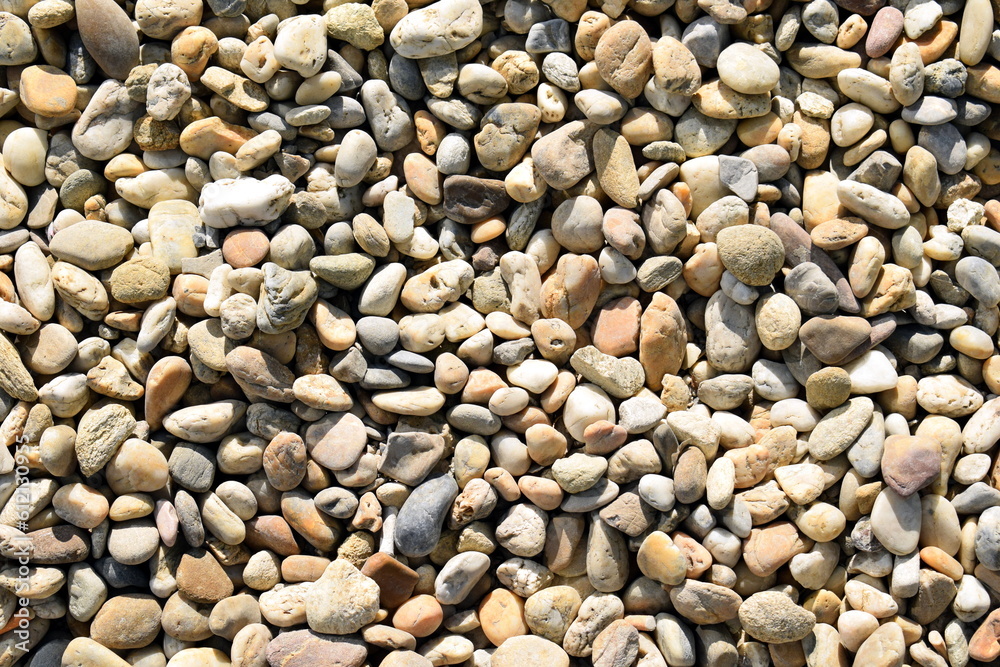 Naklejka premium Pebble stones on the ground with different surface color and structure pattern