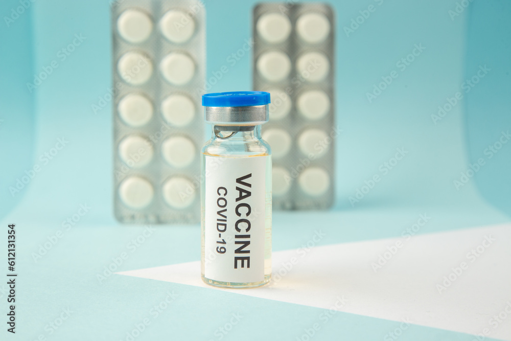 Close up shot of vaccine in medical ampoule packed pills for Covid- treatment on pastel blue background Close up shot of vaccine in medical ampoule packed pills for Covid- treatment on pastel blue background