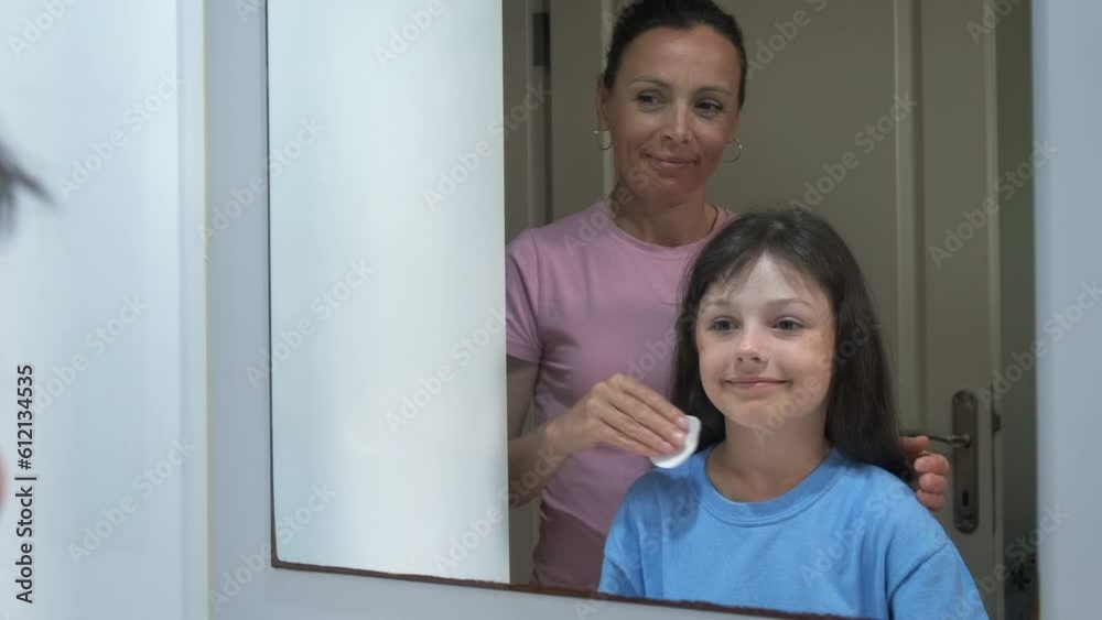 Child skin care. A mother teaches her daughter how to take care of her