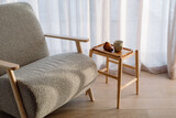 Side table with croissant and coffee near armchair