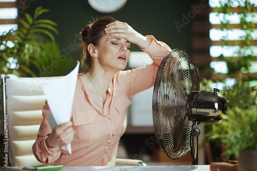 Obraz na plátne 40 years old woman employee at work suffer from heat