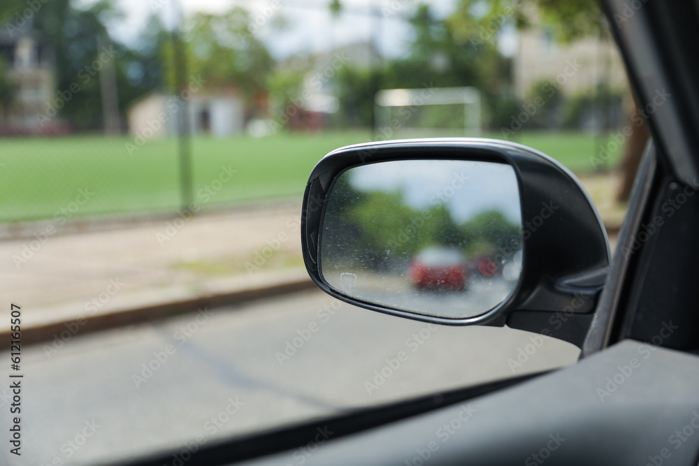 A car mirror reflects the journey ahead, symbolizing self-reflection, perspective, awareness, and the constant pursuit of progress