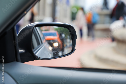 A car mirror reflects the journey ahead, symbolizing self-reflection, perspective, awareness, and the constant pursuit of progress photo