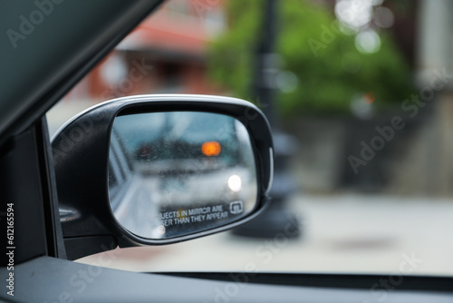 A car mirror reflects the journey ahead, symbolizing self-reflection, perspective, awareness, and the constant pursuit of progress