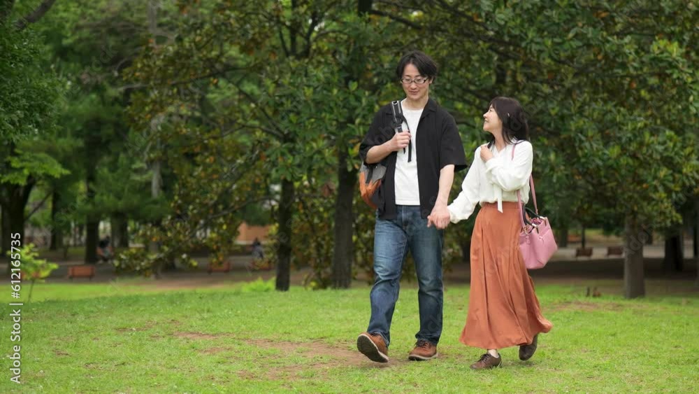 手をつないで公園を歩くカップルのスローモーション 手をつないで公園を歩くカップルのスローモーション