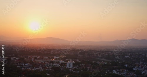 Panning Aerial shot capturing stunning sunrise that reveals the cityscape of Cuernavaca, Morelos in the country of Mexico. photo